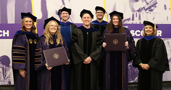 group of summer graduates and mentors in regalia